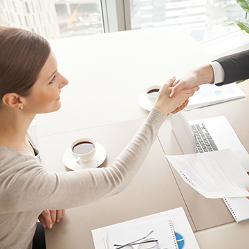 签订房屋买卖合同后，妇女与房地产经纪人握手