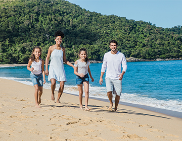 Een gezin dat langs het strand wandelt Een gezin dat langs het strand wandelt