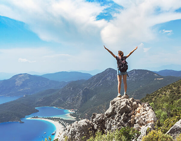 Wandelaar die uitkijkt over de zee, natuur en berglandschappen Wandelaar die uitkijkt over de zee, natuur en berglandschappen