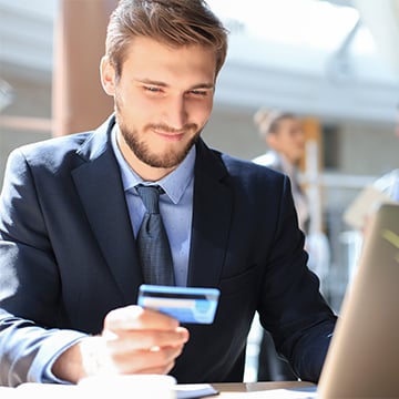 young man holding a credit card at office