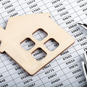 wooden mini house on papers with numbers wooden mini house on papers with numbers
