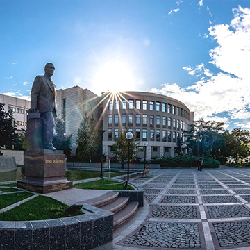 an university building with a statue in front of it an university building with a statue in front of it