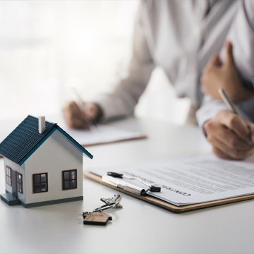 deux personnes signent un contrat tandis que la caméra se concentre sur une maison miniature et une clé deux personnes signent un contrat tandis que la caméra se concentre sur une maison miniature et une clé