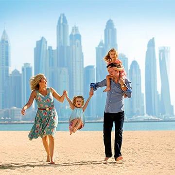 happy family on beach while skyscrapers in background