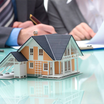 miniature house on table while two person working on the background miniature house on table while two person working on the background
