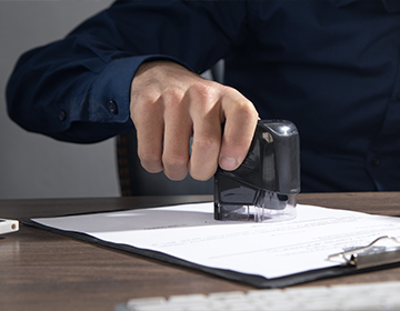 businessman-puts-stamp-documents-office