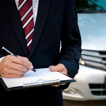 Persona llenando un formulario frente a un automóvil Persona llenando un formulario frente a un automóvil