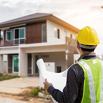 Bauarbeiten prüfen Pläne vor einem Haus Bauarbeiten prüfen Pläne vor einem Haus
