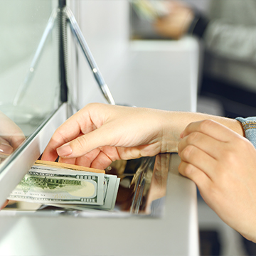 person taking money from on the tray at counter person taking money from on the tray at counter